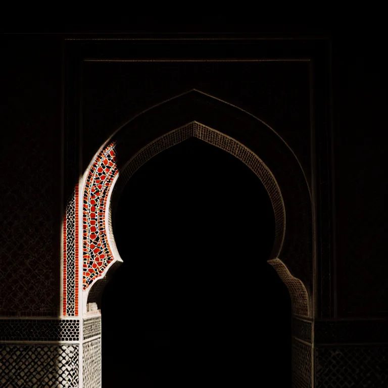 Illustration : porte en arc outrepassé ornée de zellige, dans une lumière rasante
