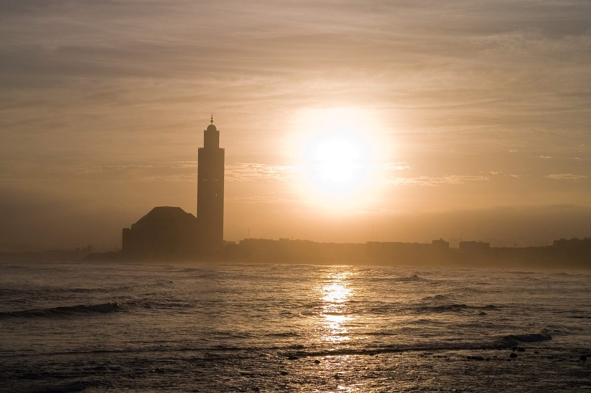 La mosquée Hassan II de Casablanca en contre-jour, au coucher du soleil sur l’océan